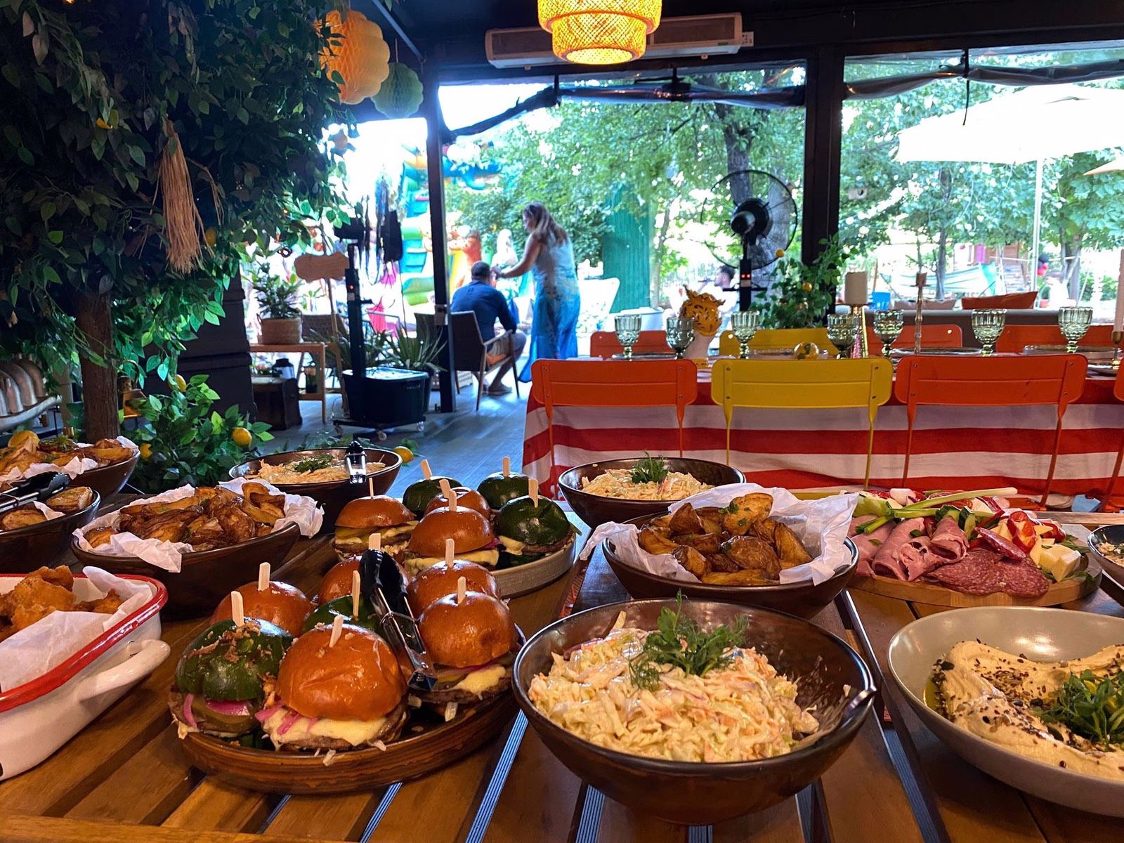Bufet din materialele Maidan, cu mini-burgeri, salate, hummus și platouri